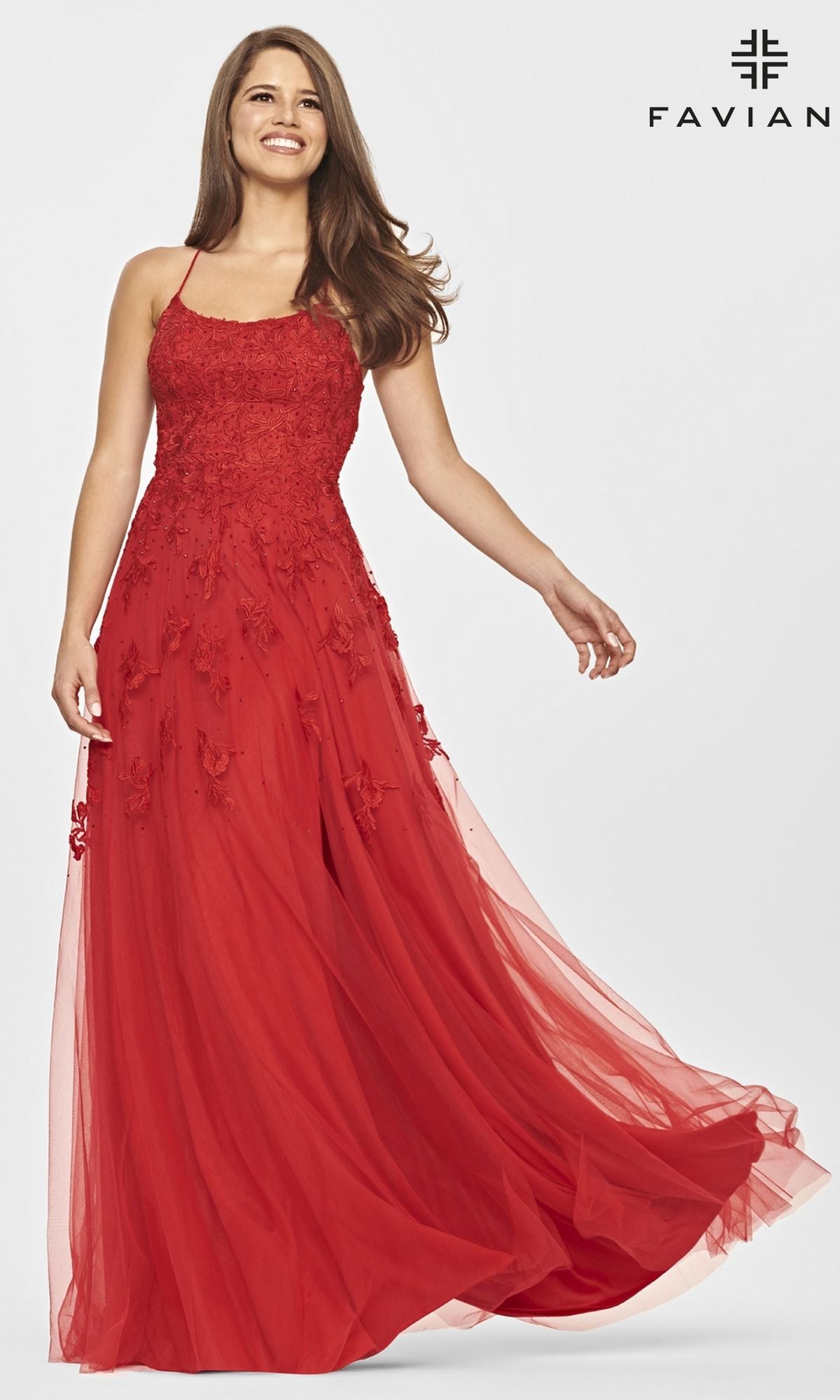 A woman models the Faviana Strappy-Back Long Lace A-Line Prom Dress in red, posing gracefully against a plain background with the Faviana logo displayed in the top right corner.